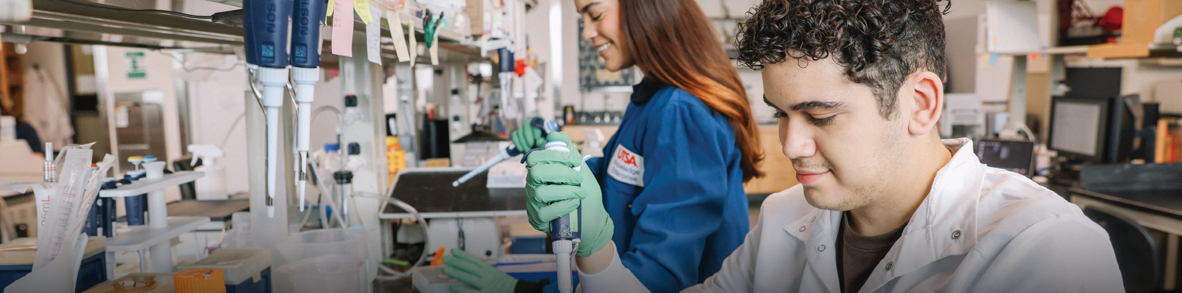 an image showing two people working with scientific equipment in a lab setting